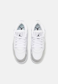 Hvite lær- og grå semsket sneakers med snøring, rund tå og svart logo på tungen. Lys blå innersåle. Jevn tekstur hele veien.