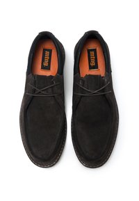 Scarpe in suede marrone con profilo basso, dotate di un accento in pelle nera sul tallone, lacci marroni e una soletta arancione.