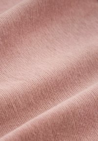 Material moale de culoare roz pal, cu o textură în dungi, care prezintă riduri subtile și o suprafață netedă. Materialul pare ușor și flexibil.