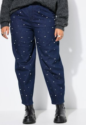 Mørkeblå denim bukser med spredte hvide perleudsmykninger, i en afslappet pasform og lige ben-design. Styles med sorte ankelstøvler.