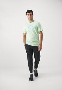 Nike Performance TEE TRAIL LOGO - Camiseta deportiva - vapor green