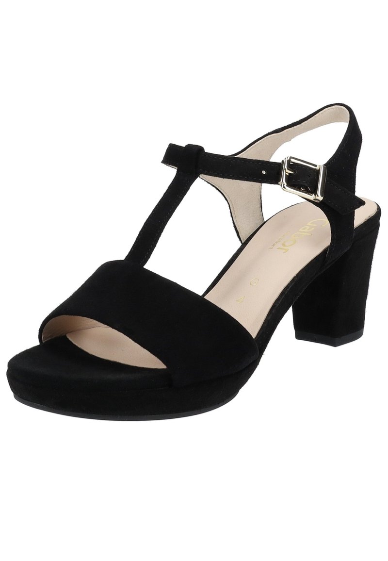 Černé semišové sandály na podpatku s designem T-pásku, otevřenou špičkou a širokým náramkem na kotníku se stříbrnou sponou. Podpatek má tvar bloku.
