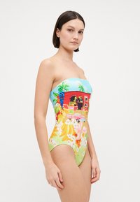 Strapless one-piece swimsuit featuring a blue top with palm tree graphics and a vibrant floral pattern in green, pink, and yellow tones.