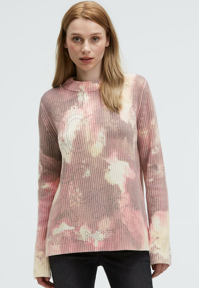 Strickpullover im pink- und cremefarbenen Batikmuster, mit geripptem Textur und rundem Ausschnitt. "ROMANCE" auf der Vorderseite aufgedruckt. Lange Ärmel.
