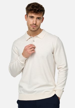 Suéter beige claro con un cuello clásico, tapeta de tres botones, mangas largas y puños acanalados. Textura de punto suave, ajuste casual.