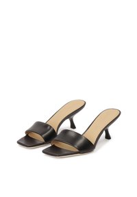 Zwarte leren muiltjes met een vierkante neus en een brede band over de voet. Voorzien van een lage stilettohak en een gladde beige binnenzool.