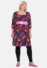 Kukkamekko kolmannelta vartalon pituudelta hihoilla, purppura tausta, kirkas vaaleanpunainen vyö, käytetty mustien legginsien ja vaaleanpunaisilla ballerinoilla.