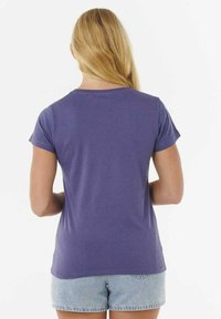 Paarse katoenen t-shirt met korte mouwen, ronde halslijn en een ontspannen pasvorm. Gladde textuur, eenvoudig ontwerp, gecombineerd met denim shorts.