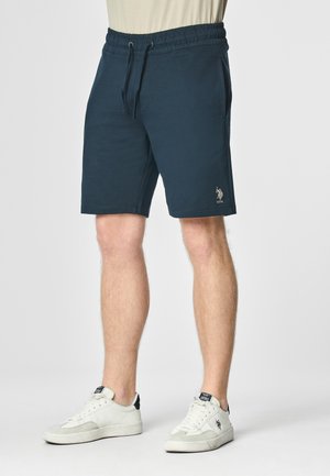 Shorts in cotone blu navy con vita elastica, cordoncino e tasche laterali. Presentano un piccolo logo ricamato sulla parte bassa della gamba sinistra.