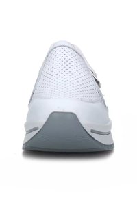 Scarpa sportiva bianca con tomaia in rete, dettagli perforati, suola grigia e design minimalista. Presenta una cintura sicura per una facilità d'uso.