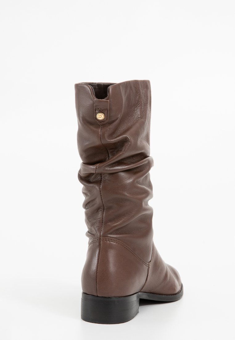 Brown leather slouch boots with a mid-calf height, featuring a rounded toe, flat heel, and a gold button accent at the back.