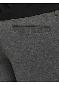 Graue Stoffhosen mit einer subtilen Textur, rückseitigem Taschen-Detail und einem Bund in einem passenden Farbton.