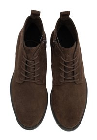 Par de botas de ante marrón oscuro con cordones hasta el tobillo, con cremalleras laterales y suelas de goma negra, vistas desde arriba sobre un fondo blanco.