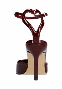 Sandale à talon haut en cuir verni bordeaux avec une bride de cheville en forme de cœur, bout ouvert et semelle beige. Le talon aiguille ajoute une touche d'élégance.