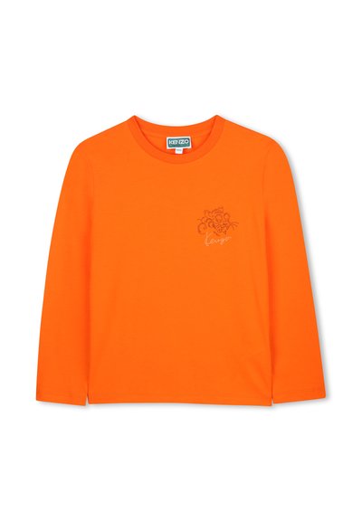 T-shirt orange à manches longues en coton avec un col rond, arborant un design graphique brodé et un logo en couleur contrastante.