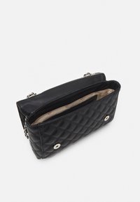 Borsa a tracolla in pelle nera trapuntata con hardware in argento, apertura superiore e foderatura interna beige. Presenta due chiusure sul davanti.