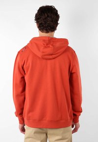 Sweatshirt rouge avec capuche et poignets côtelés. Présente un petit logo sur l'épaule et un tissu doux et texturé.