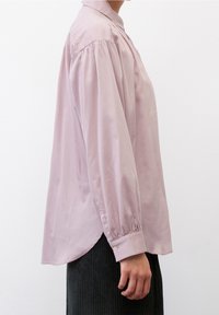 Camicia a maniche lunghe rosa chiaro con vestibilità comoda, spalle arricciate e polsini con bottoni, realizzata in un tessuto morbido e con orlo arrotondato.