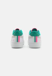 Baskets blanches avec des accents turquoise, des bandes roses et vertes, un panneau arrière texturé et un détail de logo sur le talon.