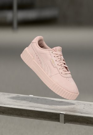 Baskets en daim rose clair avec une tige texturée, un bout perforé et une semelle en caoutchouc épaisse. Logo PUMA en accent sur la languette.