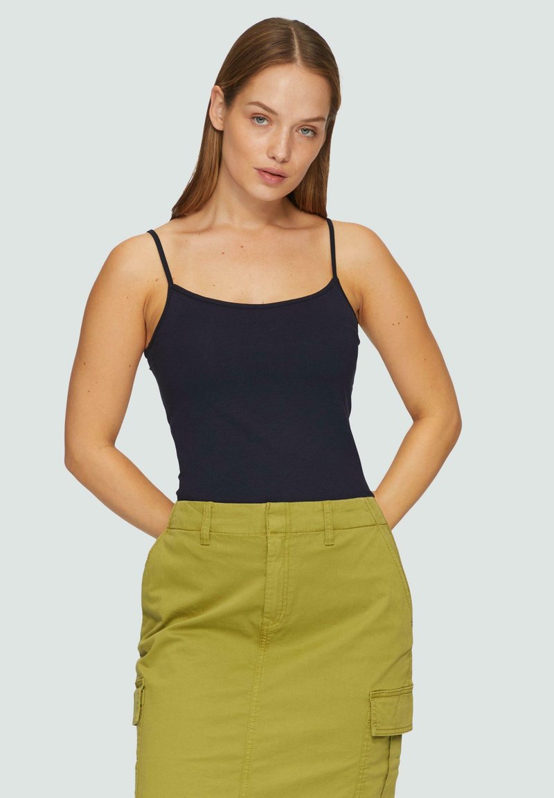 Zwarte fitted tanktop met dunne bandjes, gecombineerd met een hooghuis, olijfgroene cargorok met zijzakken en een stevige textuur.