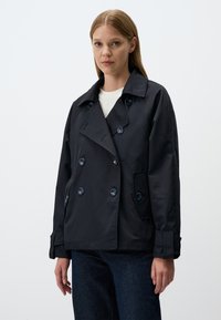 Granatowa dwurzędowa marynarka z dużymi guzikami, szerokim kołnierzem i dwoma bocznymi kieszeniami, wykonana z gładkiego, lekkiego materiału.