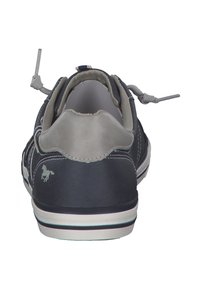 Baskets marines avec un talon en cuir gris, des lacets élastiques et une semelle en caoutchouc blanche. Présente un petit logo de cheval sur le talon.