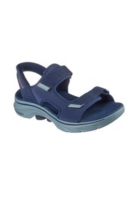 Sandalia azul marino con correas ajustables, plantilla acolchada, suela contorneada y tela texturizada. Diseño ligero y abierto en la parte delantera.