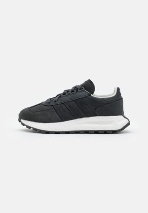 Baskets basses noires avec lacets noirs, semelle texturée et semelle intermédiaire blanche rembourrée, vues de côté sur fond blanc.