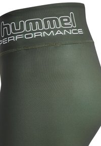 Zielone legginsy sportowe z wysokim stanem i białym logo. Materiał wydaje się gładki i elastyczny, idealny do aktywności fizycznej.