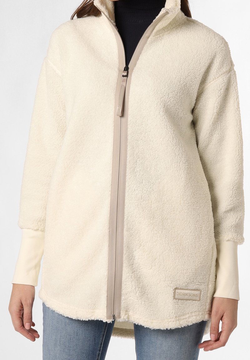 Veste en polaire blanc cassé avec col haut, fermeture éclair sur toute la longueur et logo en patch. Tissu texturé ; présente de larges manches amples et un ourlet arrondi.