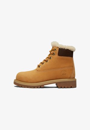 Ruskea nahkainen nilkkasaappaat, joissa on pehmeä tekoturkisreunus, metalliset nyöriaukot ja kumipohja, jossa on syvät urat pidon takaamiseksi. Timberland-logo kohokuvioitu.