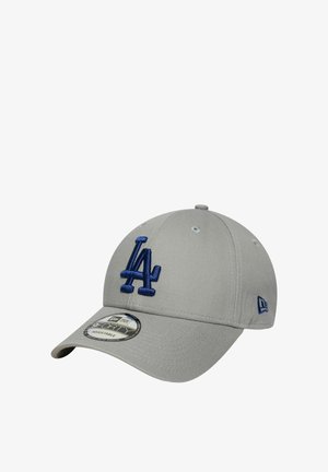 Gorra de béisbol gris con visera curva, que presenta un logo bordado en relieve de color azul con "LA" en la parte frontal y ojales de ventilación en la corona.