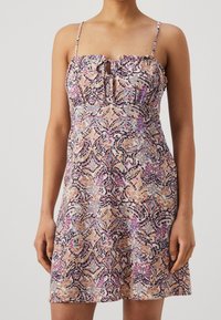 Šaty s květinovým potiskem, tenkými ramínky, volánkovým výstřihem a detailem ve tvaru klíčové dírky. Obsahují kombinaci pastelových barev na texturované látce.