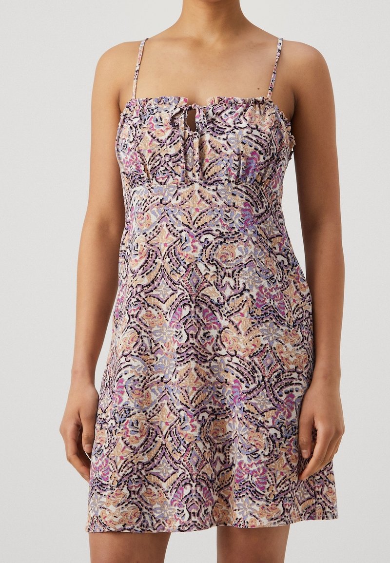 Šaty s květinovým potiskem, tenkými ramínky, volánkovým výstřihem a detailem ve tvaru klíčové dírky. Obsahují kombinaci pastelových barev na texturované látce.