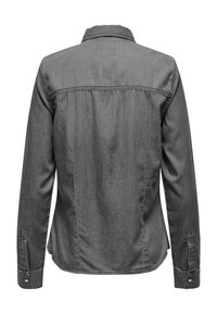 Camisa de mezclilla gris con cuello abotonado, mangas largas y puños. Textura suave con detalles sutiles en los hombros y la costura trasera.