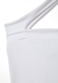 Vestido blanco de un solo hombro hecho de una tela suave, con un escote drapeado y una silueta elegante. Diseño limpio y minimalista sin patrones.