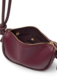 Sac à main en cuir bourgogne avec une finition texturée, fermeture éclair et détails en métal doré. Forme compacte avec une poche intérieure.