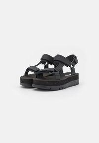 Svarta sandaler med en robust design, breda remmar, justerbara spännen och en dämpad, fläckig sula för komfort och stöd.