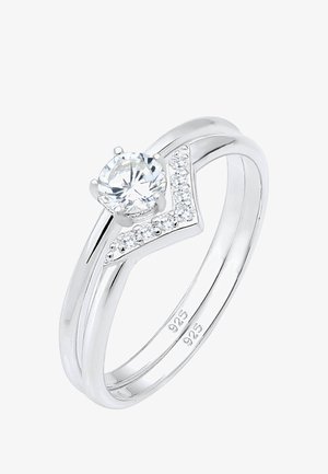 Sterling zilveren ring met een ronde centrale steen en kleine accentstenen aan één kant. Heeft een gladde, gepolijste afwerking.