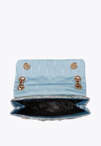 Jasnoniebieska torebka o teksturowanej powierzchni, z złotymi elementami i łańcuchowymi akcentami. Wnętrze ozdobione jest ciemnym wzorem. Widok z otwartej torebki ukazuje rozmieszczenie przegródek.