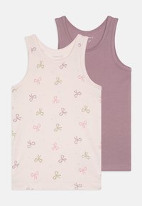 Two tank tops: one in light pink with multicolored bow patterns, the other in solid lavender. Both have wide straps and a soft cotton texture.