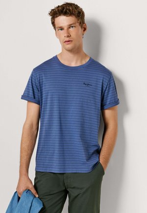 Blue striped t-shirt in cotton, featuring rolled sleeves, a round neckline, and a small logo at the chest. Worn with green pants.