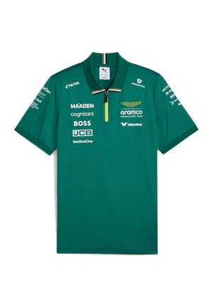 Polo verde del equipo Aston Martin de Fórmula Uno con logotipos de patrocinadores, cuello con cremallera y marca Puma sobre un fondo blanco.