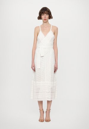 Witte kanten midi-jurk met een V-hals, verstelbare spaghettibandjes, een strikceintuur en een patroon aan de zoom. Soepele textuur met gelaagde details.