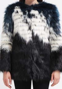 Kabát z umělé kožešiny s barevným blokováním v modré, bílé a černé. Dlouhé, měkké vlákna vytvářejí texturovaný vzhled; otevřený přední design; široký límec.