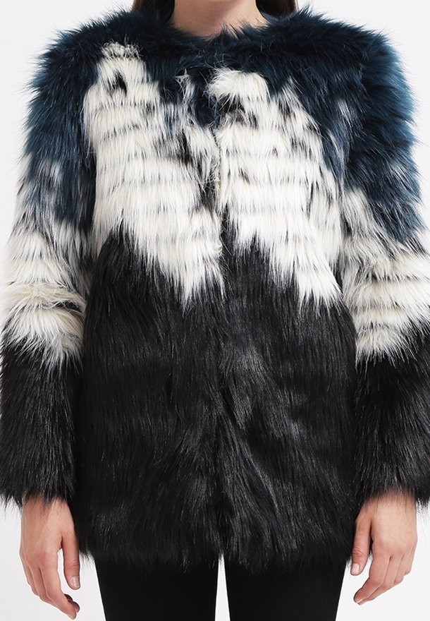 Kabát z umělé kožešiny s barevným blokováním v modré, bílé a černé. Dlouhé, měkké vlákna vytvářejí texturovaný vzhled; otevřený přední design; široký límec.