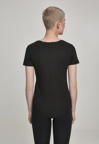 Sort kortærmet t-shirt med rund halsudskæring, lavet af glat bomuld, med en buet kant og et enkelt, klassisk design.