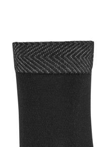 Sort sok med et tekstureret hørmønster ved toppen af skaftet og en glat finish på kroppen, som fremhæver kontrasten mellem materialerne.