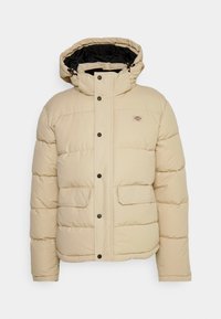 Veste d'hiver rembourrée beige avec capuche, doublure intérieure noire, fermeture avant à boutons-pression, deux poches à rabat à l'avant et petit logo sur la poitrine.